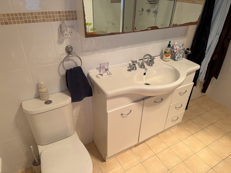 Old cream vanity, aged mirrored shaving cabinet and original toilet in the Warriewood bathroom before the refresh