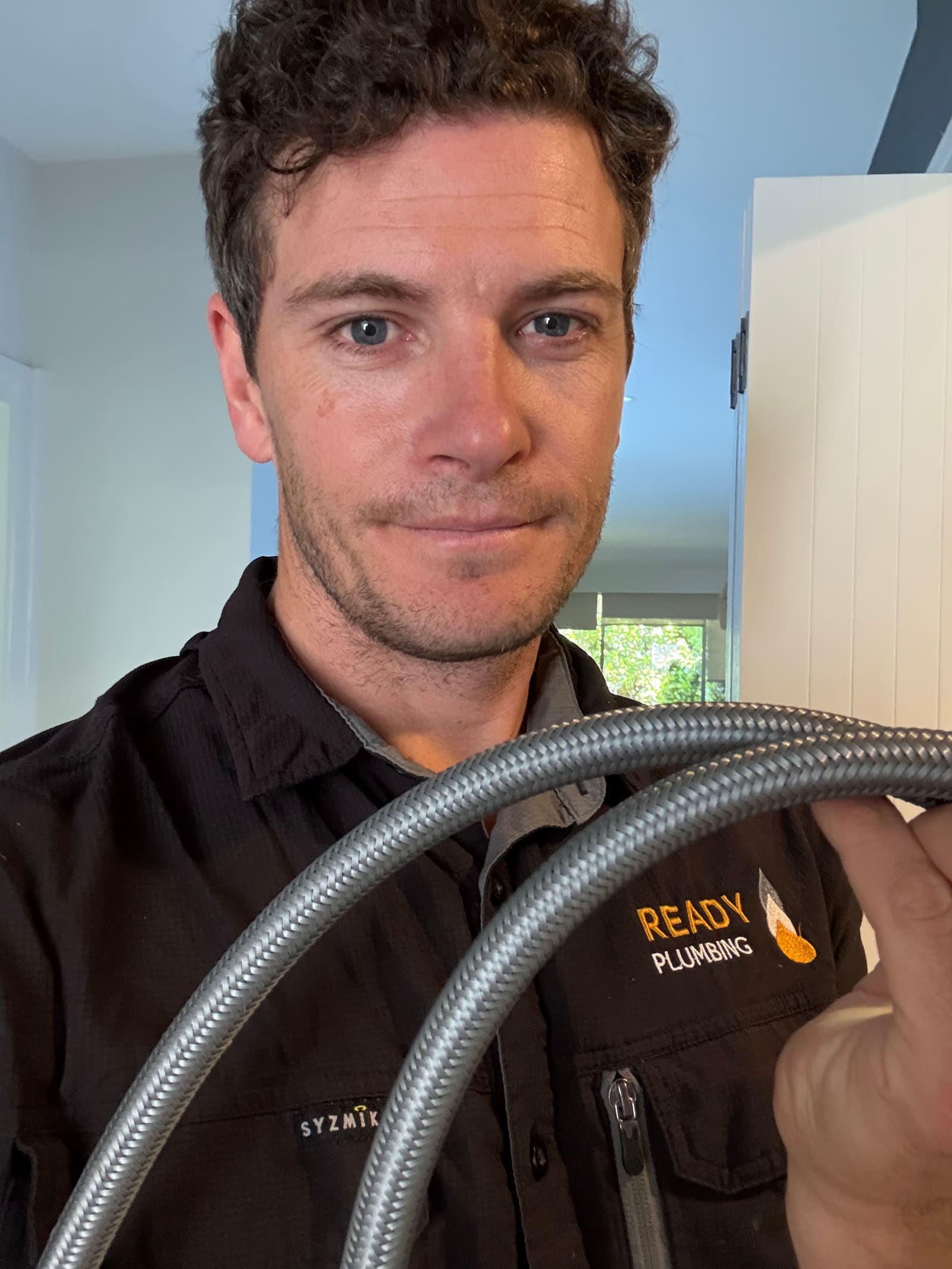 Nick from Ready Plumbing holding one of the new polymer hoses fitted in Balgowlah