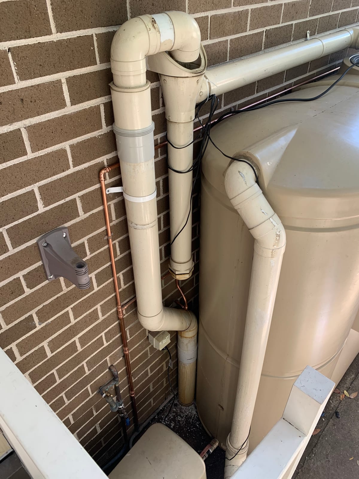 Close-up of rainwater tank pump and plumbing connections installed by Ready Plumbing